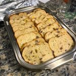 Topping the Bananas Foster sauce with the bread to rest and soak up overnight, taken by Allspice Photography, LLC.