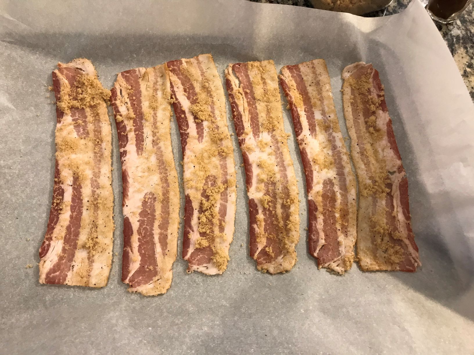 Laying out the bacon on parchment and a sheet tray, taken by Allspice Photography, LLC.