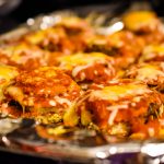 Baked eggplant topped with sauce and cheese, taken by Allspice Photography LLC.